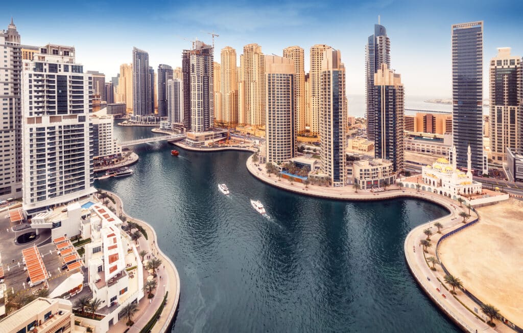 Vue aérienne de la Marina de Dubaï, gratte-ciel modernes, canal turquoise, bateaux, promenade et mosquée.